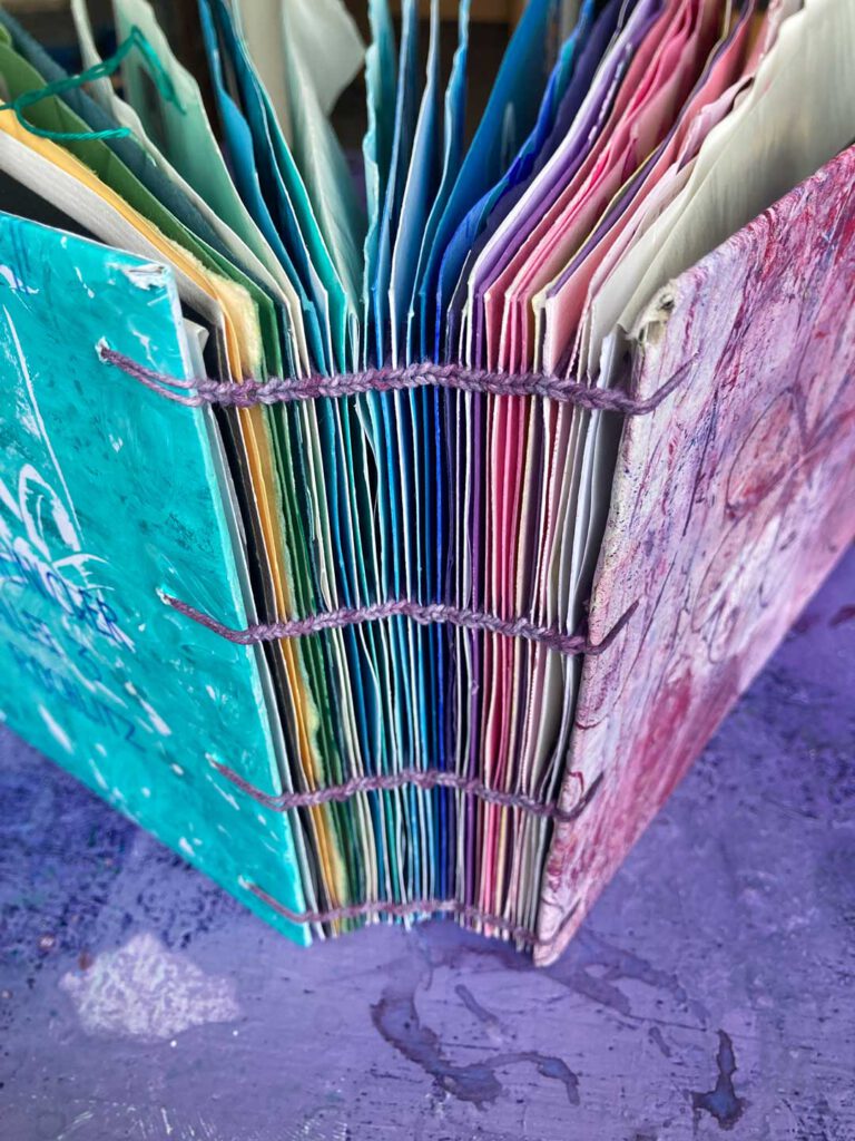 Wundewrschönes Buch! Das bunte BUch steht aufgefächert auf der lila Schreibtischplatte von Tabea.
