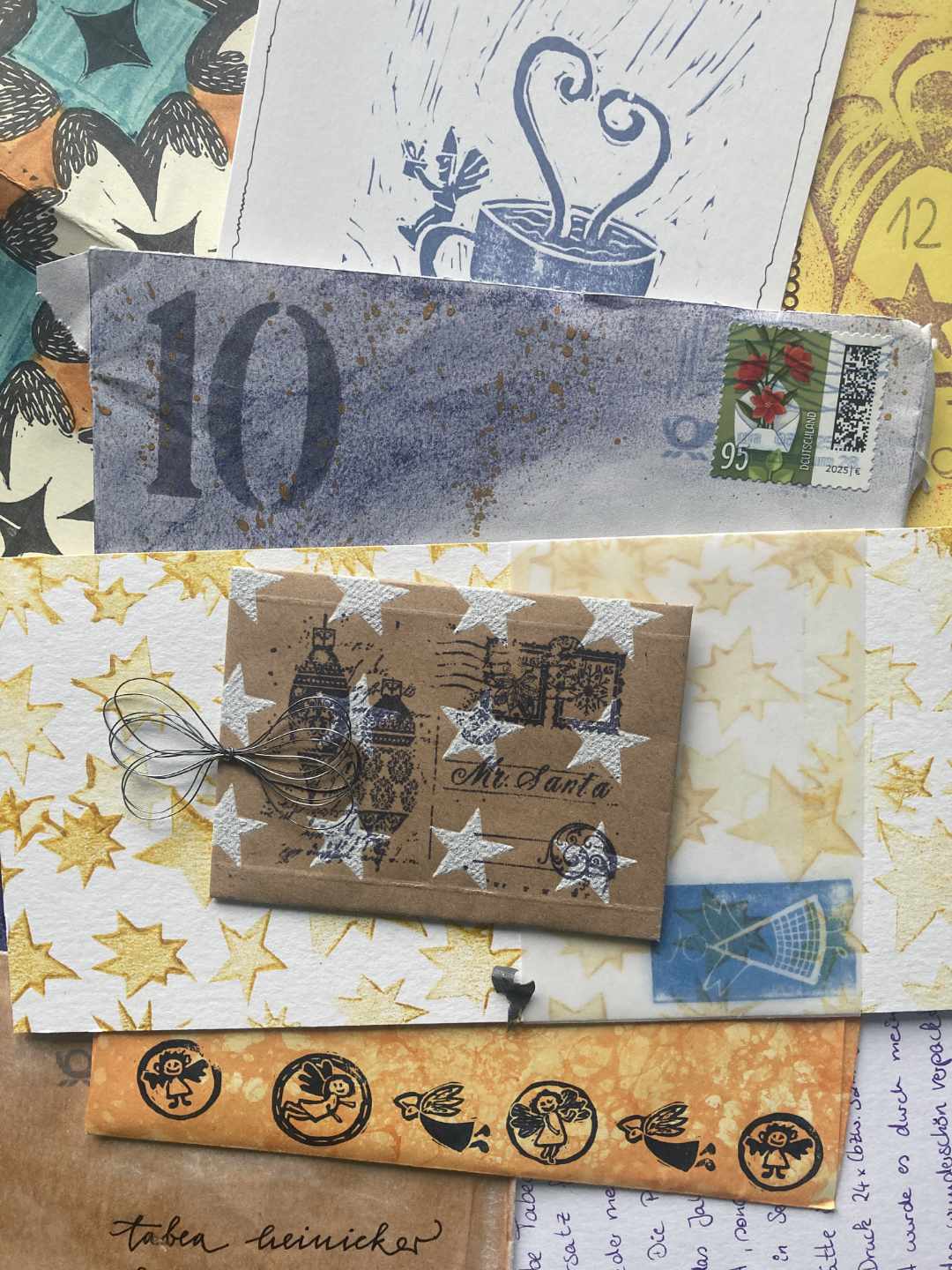 Pastelltöne, Farbsprenkler, ein elfenhafter Engel sitzt auf einem Henkel einer Tasse. Minumschläge, Sterne und ein gestempeltes Relief mit kleinen Engelchen.